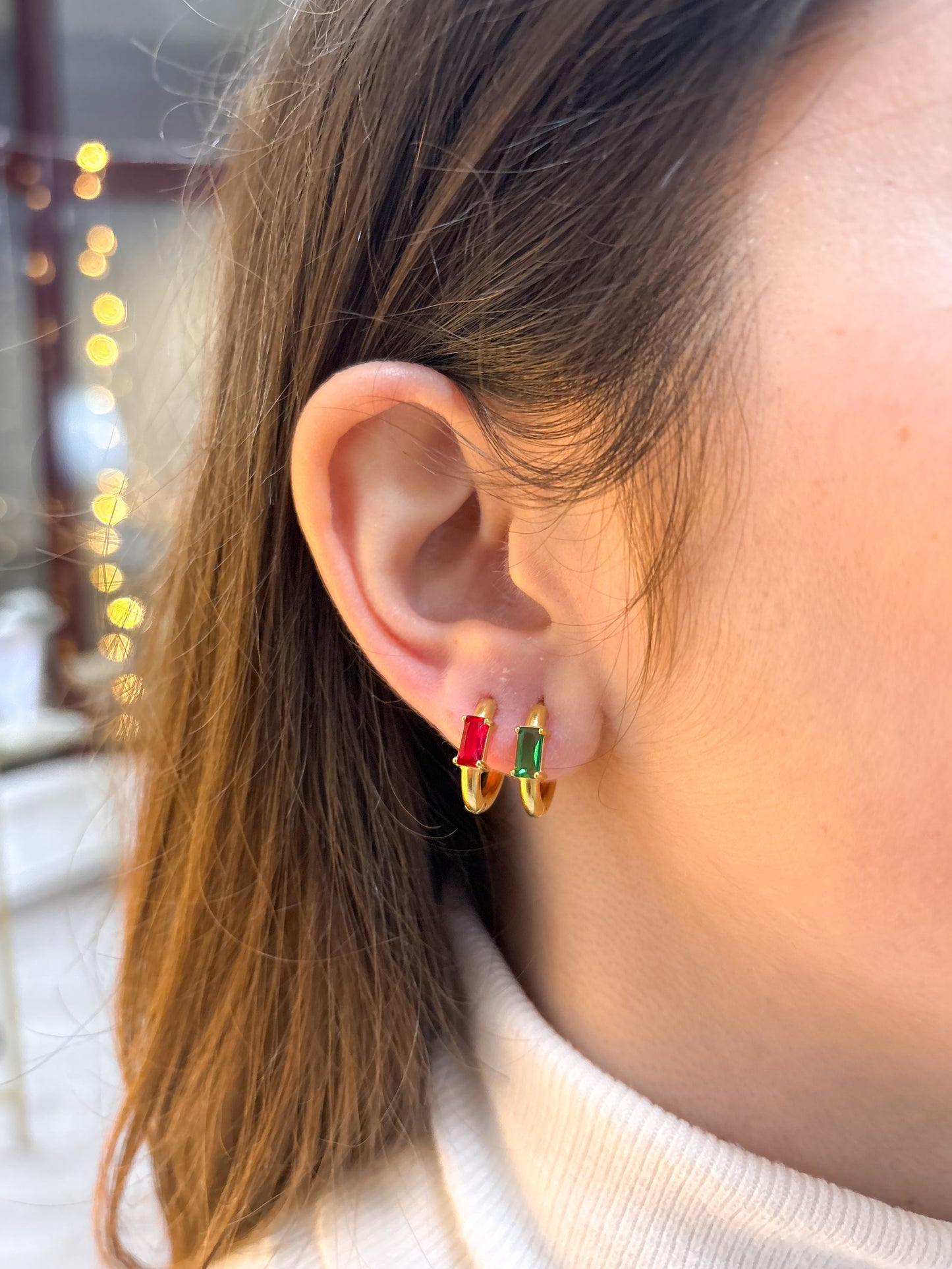 modelo usando brincos yara verde e dourado aço inox