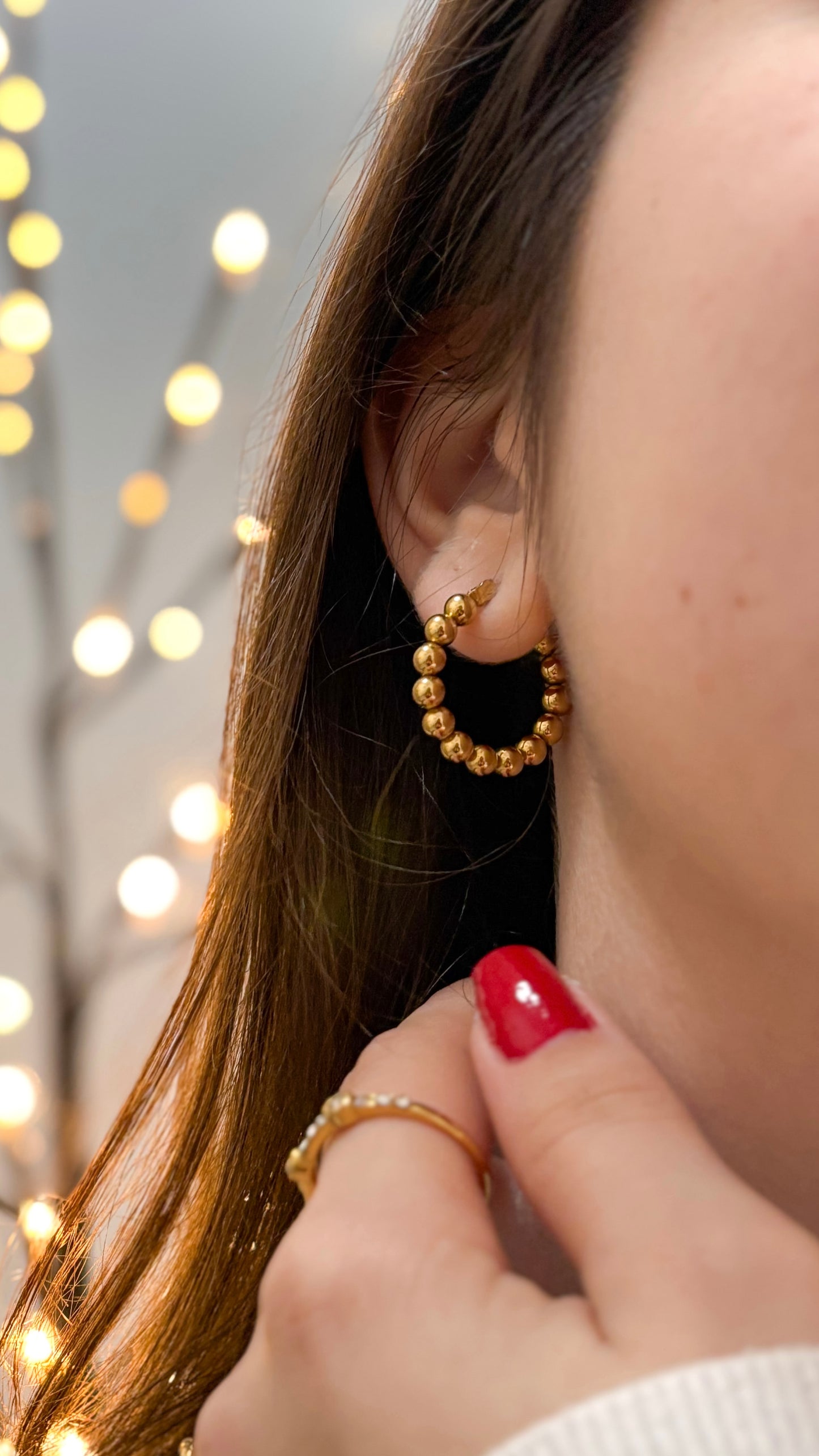 
modelo usando brincos bolinhas douradas aço inoxidável