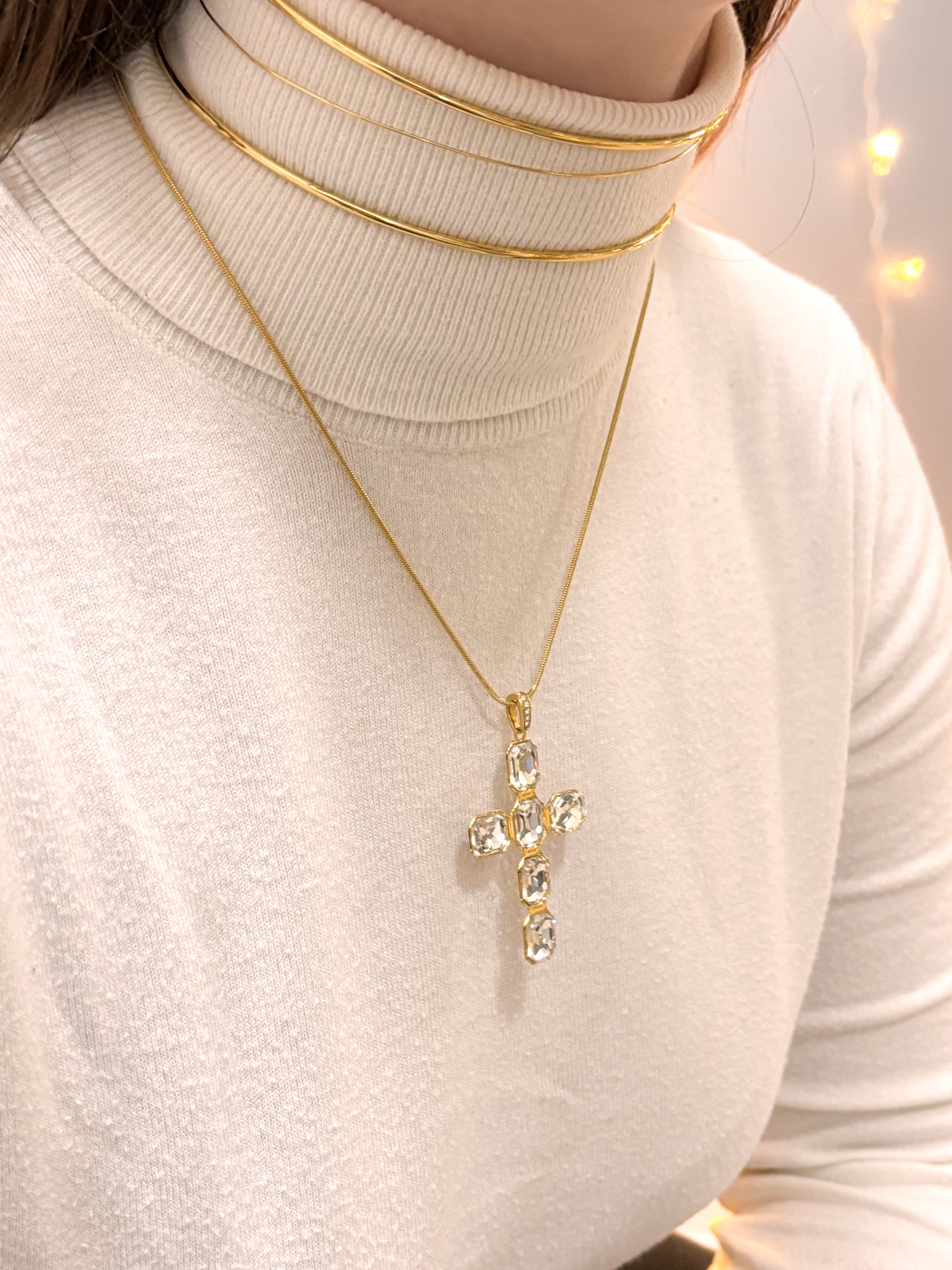 modelo usando colar cruz dourada aço inox